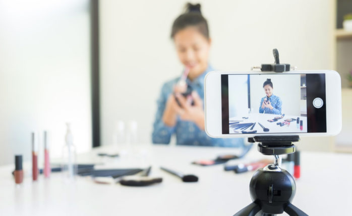 A young professional using her smartphone to live stream | Indypendenz | Shutterstock.com